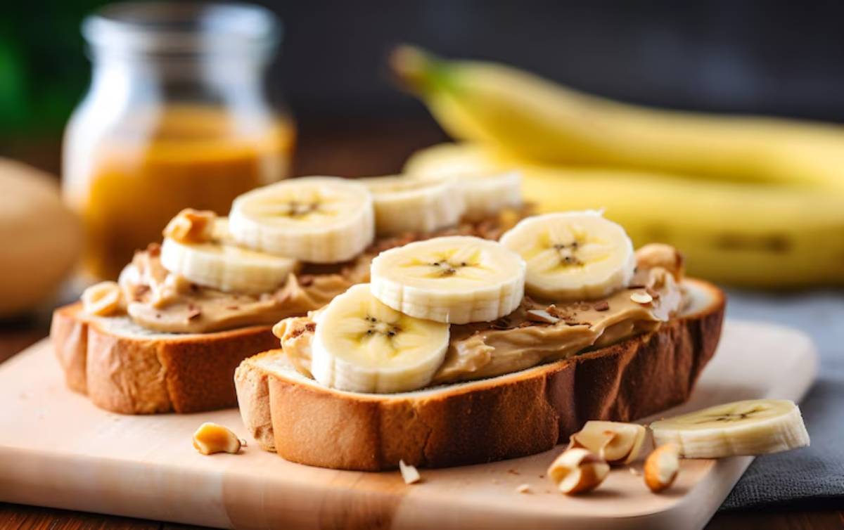 Whole grain toast topped with creamy peanut butter, banana slices, and chopped walnuts, served on a light plate.